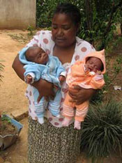 Photo of Pauline holding rescued twin babies